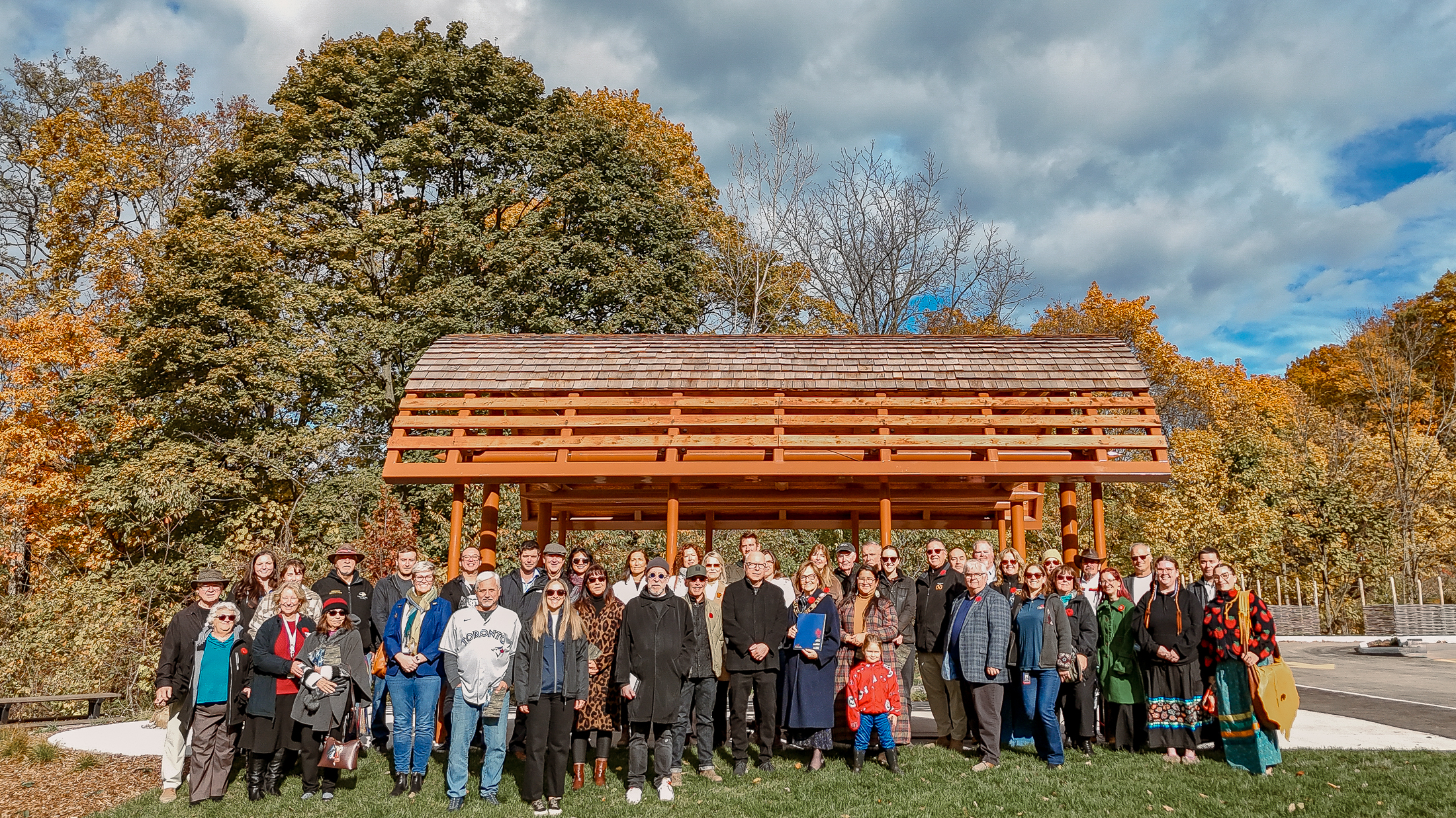 Large group of people standing on the east side of the park's long house structure.