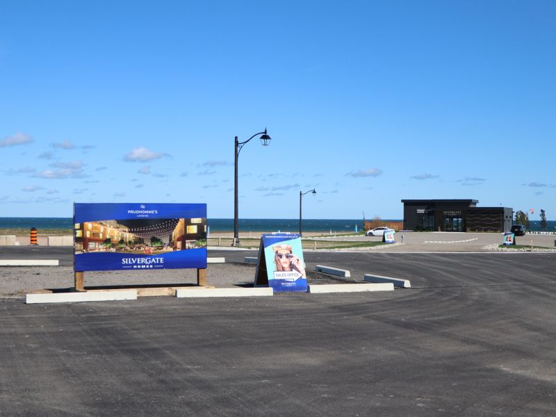 Signage on a roadway with a building in the distance.