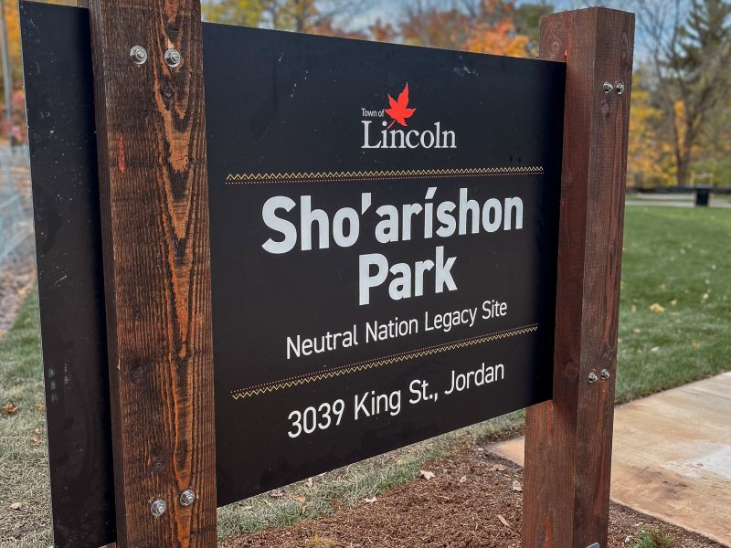 Park name on sign being held up by two wooden beams.