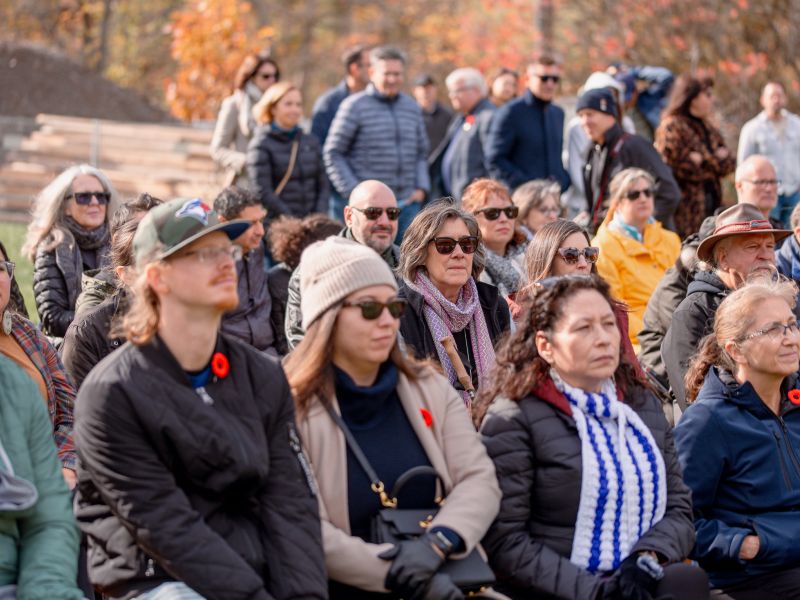 Some people sitting and others standing looking into the distance.