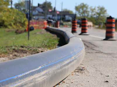 Watermain pipes beside road and pylons.